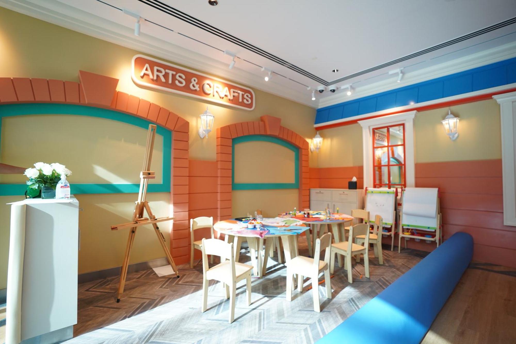 Grand Hyatt Dubai Hotel Exterior photo The photo shows a brightly colored arts and crafts room. The walls are painted in warm shades with decorative elements, including an "ARTS & CRAFTS" sign prominently displayed. There is a large wooden easel, indicating space for creative activities, 